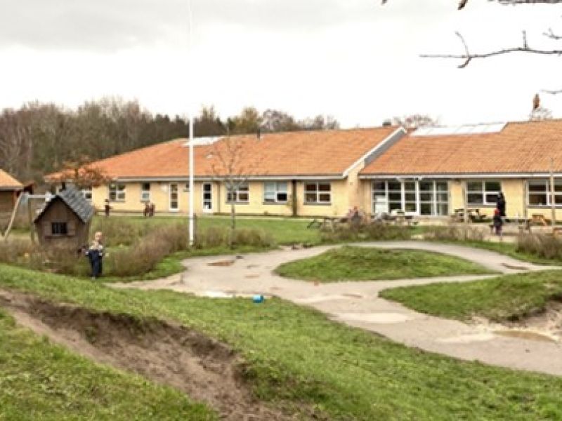 Foto af institutionsbyggeri med legeplads, hvor HBO Solutions har rådgivet om energioptimering og elinstallationer.